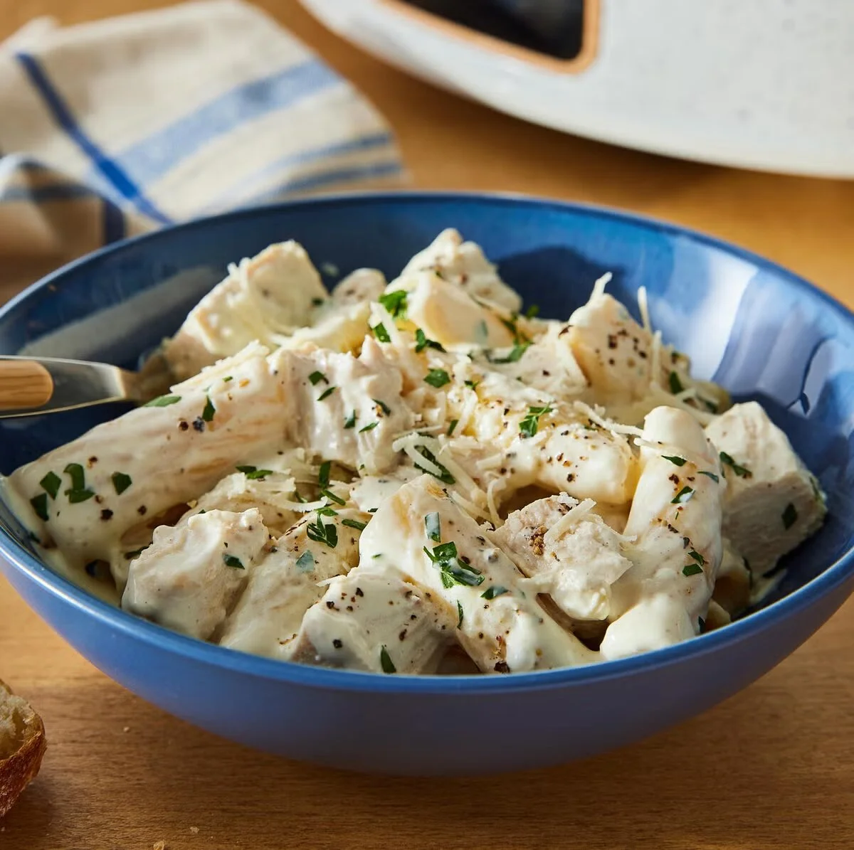 Delicious slow cooker creamy chicken alfredo served in a bowl with parsley garnish